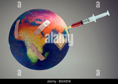 Still shot of a world globe with band aids on Africa and a syringe on Asia Stock Photo