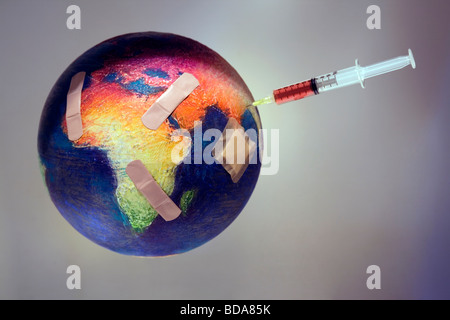 Still shot of a world globe with band aids on Africa and a syringe on Asia Stock Photo