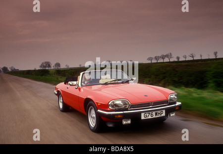 Jaguar XJS driving down English country road Stock Photo