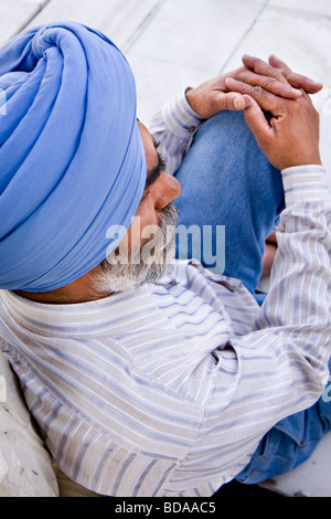 A Sikh man sitting down in a deep thought Stock Photo