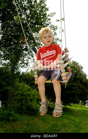 Baby blond boy on the swing - seesaw Stock Photo