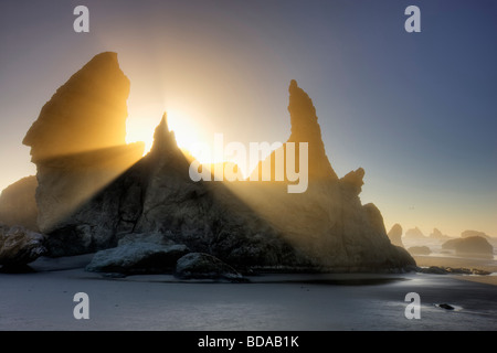 Sea stacks at Bandon Beach with fog and sun rays Oregon Stock Photo