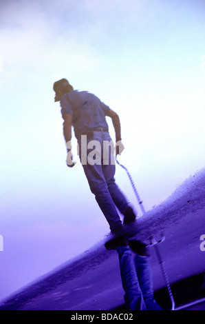 Senior Man walking with cane reflected in puddle Stock Photo