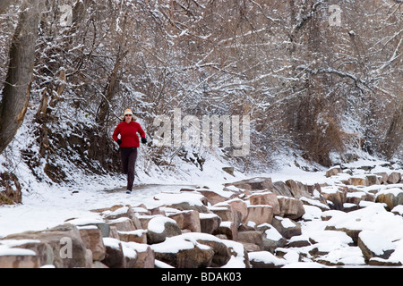A female athlete runs along a trail in the foothills of the Rocky Mountains near Boulder, Colorado Stock Photo