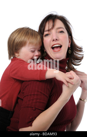 joyful mother and son with down syndrome in school uniform holding gift