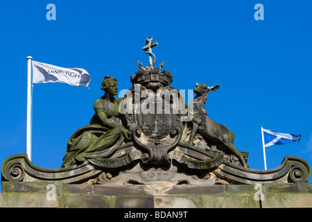 The flags of Scotland and Edinburgh fly next to a stone carving of the Edinburgh Coat of Arms. Stock Photo