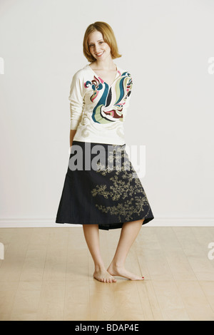 Portrait of a young woman standing with her hands behind her back Stock Photo