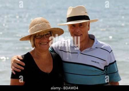 Portrait of a man and woman wearing sunhats at the seaside Stock Photo
