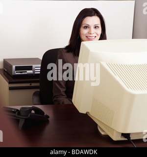 Portrait of a businesswoman working on a desktop PC and smiling Stock Photo