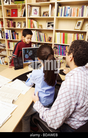Rear view of a mature man with his two children using a computer Stock Photo