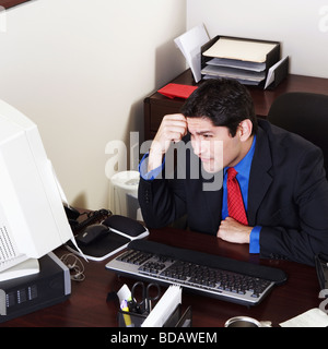 Businessman working on a desktop PC in an office Stock Photo