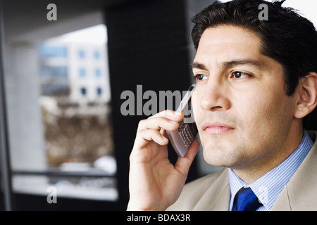 Close-up of a businessman talking on a mobile phone and looking away Stock Photo