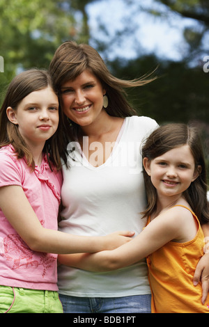 Portrait of a young woman with her two sisters in a park Stock Photo