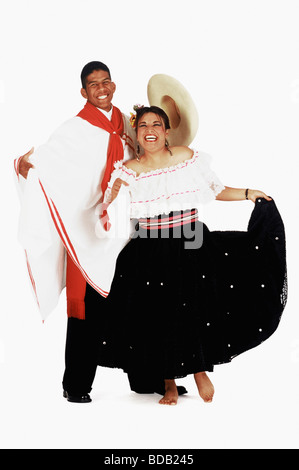 Portrait of a young man with a mid adult woman performing folk dance and smiling Stock Photo