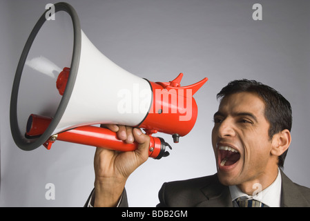 Businessman shouting into a megaphone Stock Photo