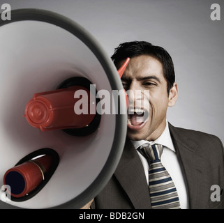 Businessman shouting into a megaphone Stock Photo