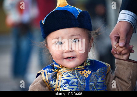 Happy, young, Mongolian boy dressed in traditional clothes and hat holds his father's hand, Ulaan Baatar, Mongolia Stock Photo