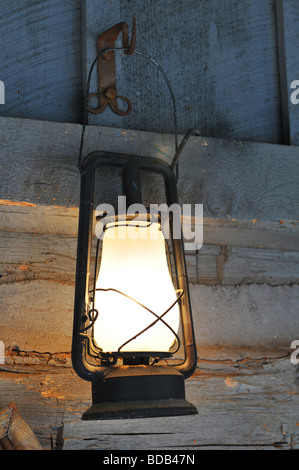 Old vintage lamp hanging from a wooden wall Stock Photo