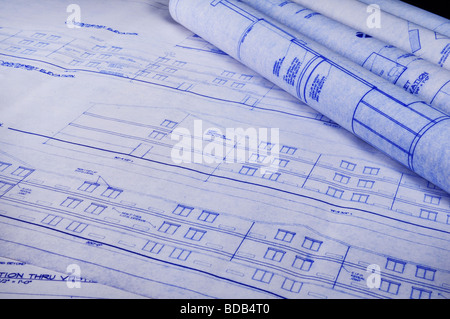 Blueprints on the table and some rolled up Stock Photo
