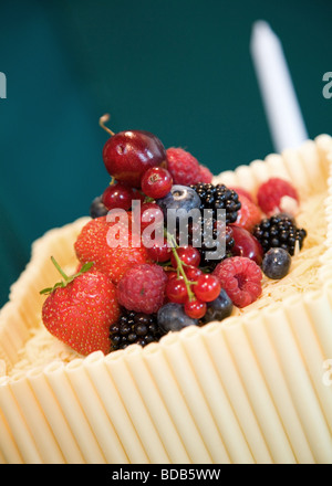 fresh fruit made up of strawberries blueberries raspberries cherries on a wedding cake made of white chocolate tubes Stock Photo