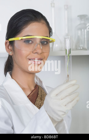 Scientist examining a plant in test tube Stock Photo