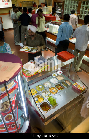 Indian customers queue for fast food for sale at the counter in ...