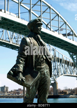 Statue of the boy Thomas Edison on the boardwalk in Port Huron Michigan. The Blue Water Bridge is in the background. Sculptor Mino Duffy Kramer Stock Photo