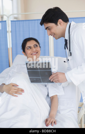 Male doctor showing ultrasound to pregnant woman Stock Photo