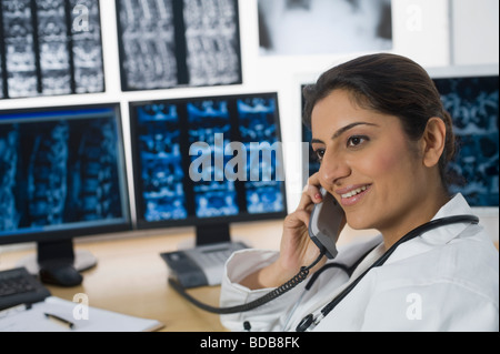 Female doctor talking on a phone and smiling Stock Photo