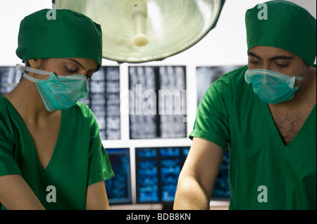 Surgeons performing surgery in an operating room Stock Photo