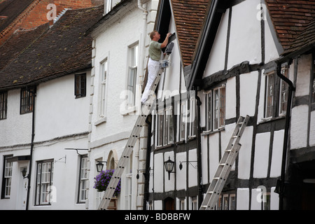 A painter at work on a house in Mill Street in Warwick UK