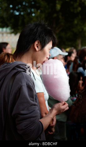 Asian Tourist tries Candy floss on South Bank, London, England, UK, Europe Stock Photo