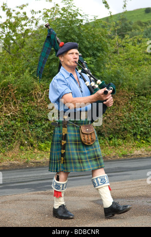 A Scotsman playing the bagpipes and wearing traditional Scottish dress Kilt, sporran etc. Stock Photo