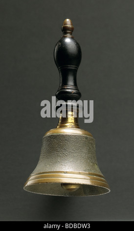 Looking up at a hand bell floating on grey background Stock Photo
