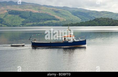 Pleasure or tourist sightseeing boat on Loch Lomond just off a village called Luss, Scotland. Stock Photo