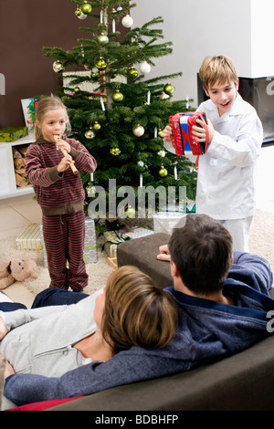 parents listening to their children playing music on christmas morning Stock Photo