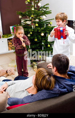 parents listening to their children making music on christmas morning Stock Photo