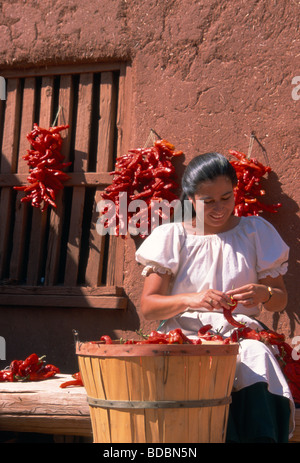 Native American woman tying red chili ristras, New Mexico Stock Photo