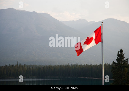 Canadian National Flag flying in Jasper National Park with the rockies behind Stock Photo