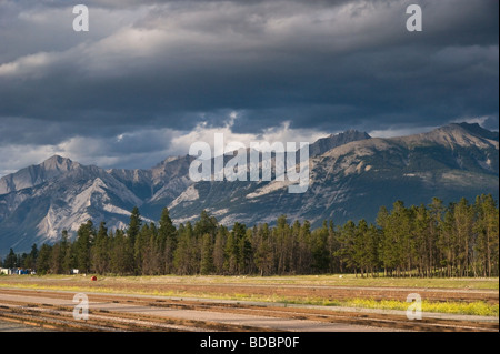 Clouds gathering over the Rocky Mountains in Jasper, Alberta - in the foreground a deserted railway yard. Stock Photo