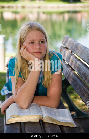 11-13 year old olds Caucasian Junior high girl reading the Bible meditating reflecting on God's Word. MR Myrleen Pearson Stock Photo
