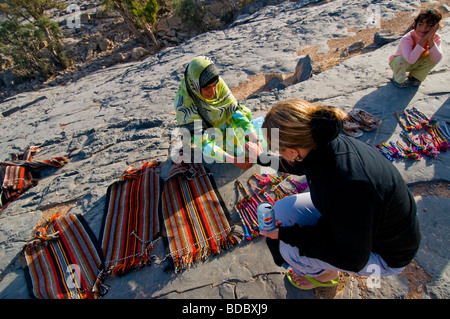 Tourist buying handicrafts from bedouin children Jabel Shams Oman Stock Photo