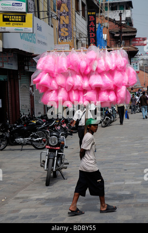young boy selling bags of pink cotton candy floss walking around durbar square kathmandu nepal Stock Photo