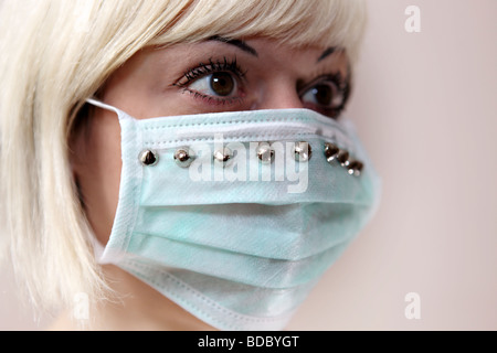 A blonde girl wears a customized surgical face mask. Stock Photo