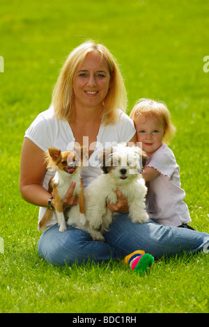 Woman and daughter with Chihuahua and Mixed Breed Dog puppy Stock Photo