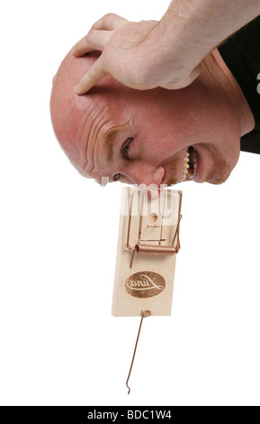 bald headed man with nose in mouse trap Stock Photo