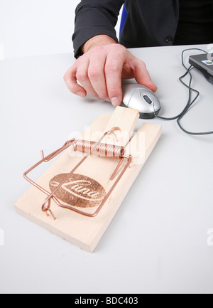 man using a laptop with mousetrap next computer mouse Stock Photo