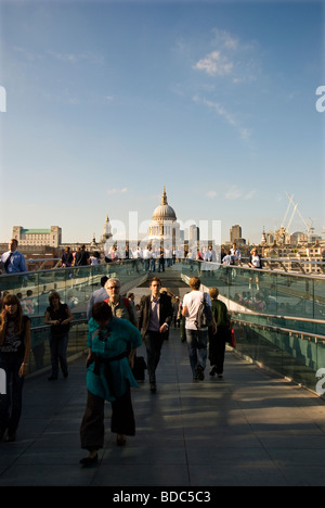 People crossing Millennium Bridge and St Paul's Cathedral in background  London England UK Stock Photo