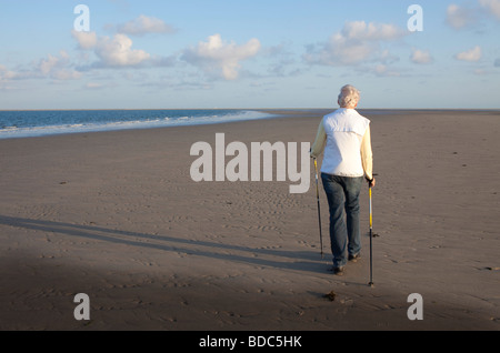 Woman walking on the beach Stock Photo