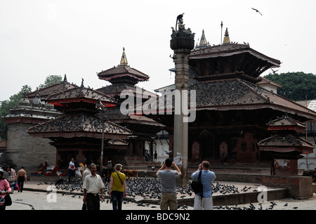 Carved wooden detail facade Jagannath temple cow calf pigeons birds tourists near Hanuman Dhoka Durbar Square Kathmandu Nepal Stock Photo